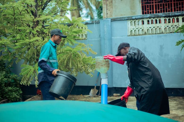 TKT operators feeding organic slurry into the biodigester